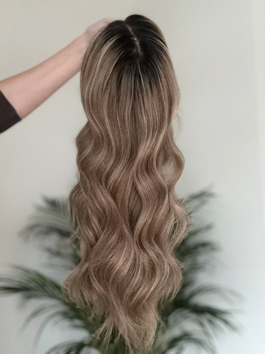 Close up of natural darker root on brown blonde balayage human hair wig