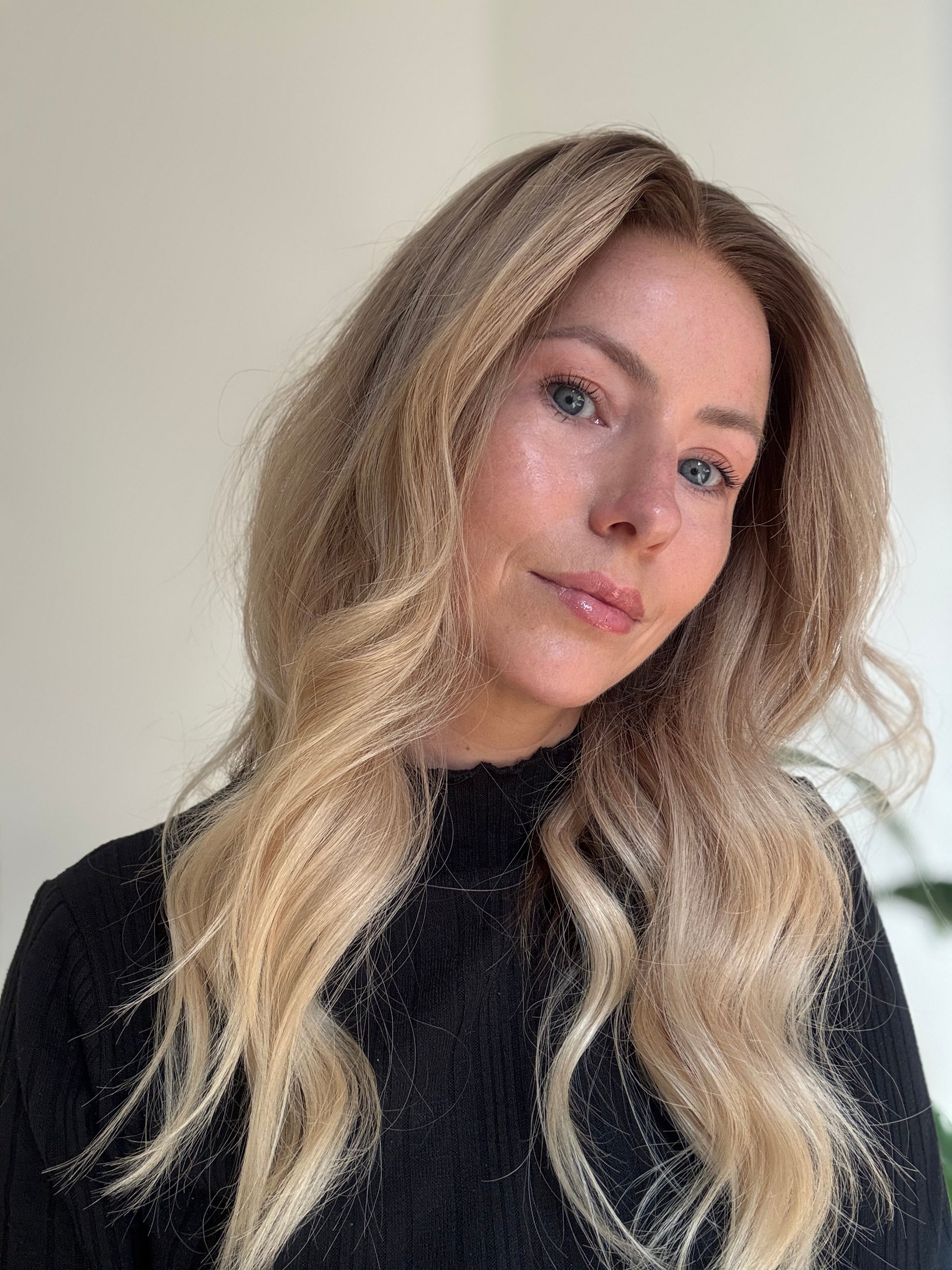 Blonde human hair wig styled with soft voluminous waves