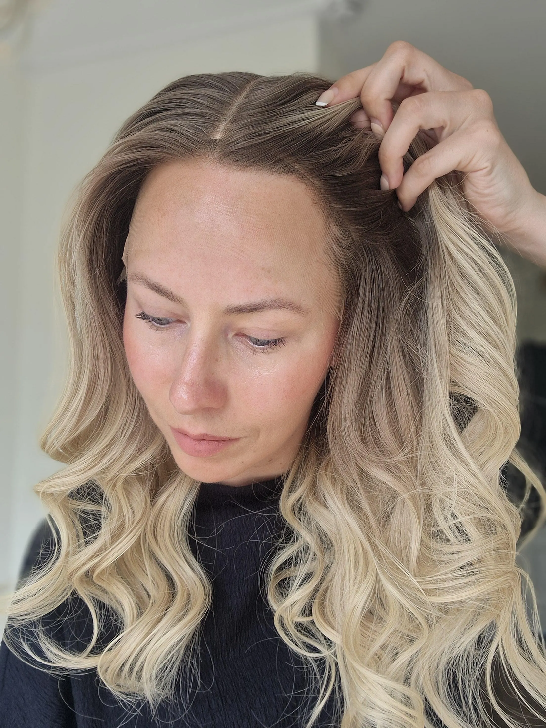 The Lisa Wig featuring an ash blonde rooted blend and natural movement